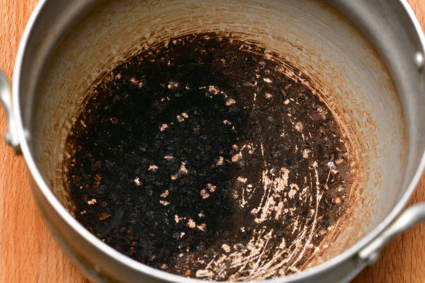 Burnt spoiled pan stands on a wooden table. Horizontal photography