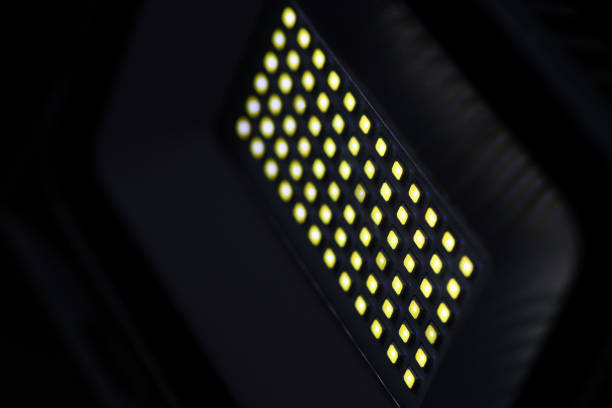istock A rectangular diode spotlight of gray color in a dark room illuminates with yellow light. Blurred background 1132210119