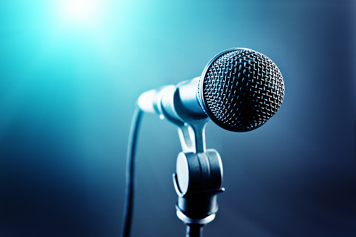 Micrófono vocal delante de luces de escenario de tonos azules photo