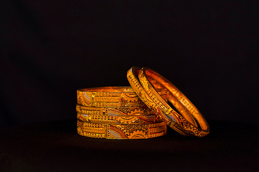 Artificial golden bangles close up on a black background