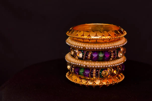 istock Artificial golden and colored bangles close up on a black background. 1132212239