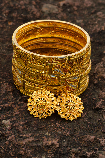 Artificial golden bangles close up on a textured background