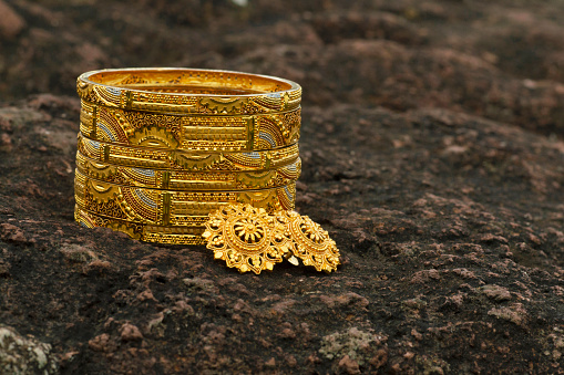 Artificial golden bangles close up on a textured background