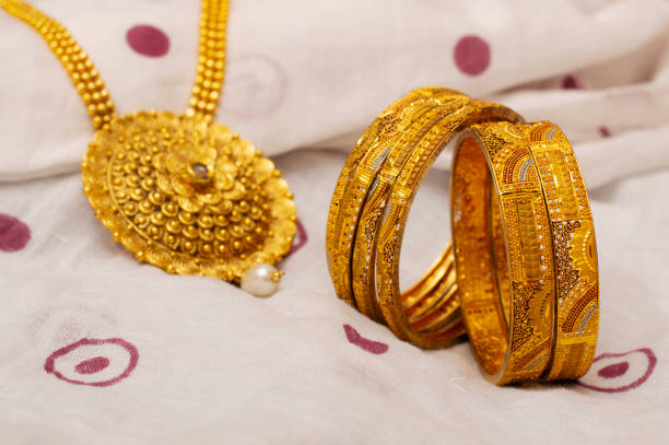 istock Close-up of artificial golden bangles and necklace. 1132212920