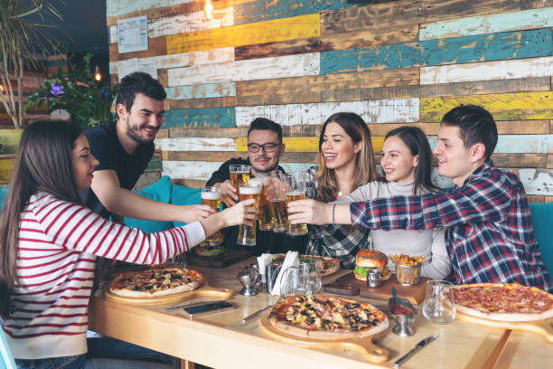 happy young friends celebrating with pizza and drinking beer at bar restaurant - beer pub women pint glass imagens e fotografias de stock