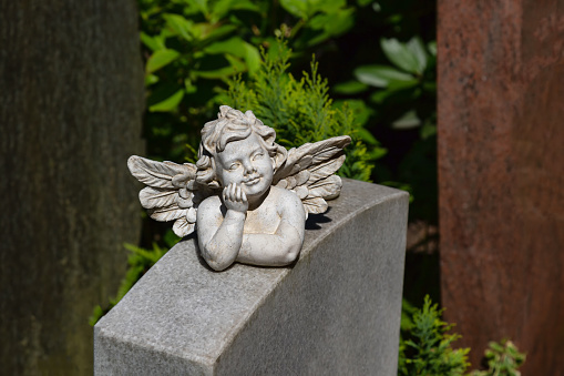 Nice angel figure is thinking on a grave stone