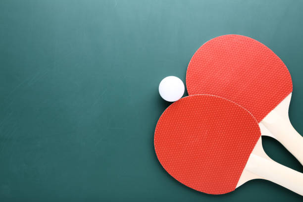 istock Table tennis rackets with ball on green background 1132216044