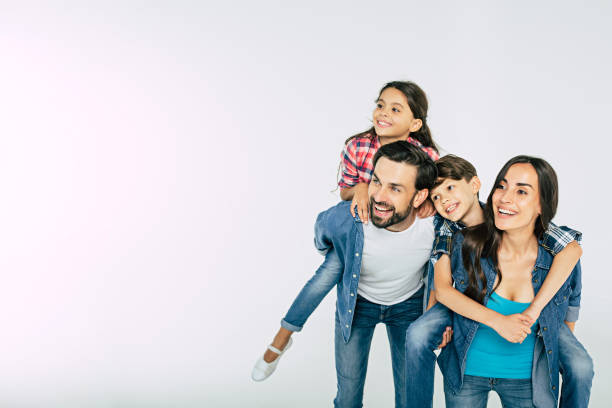 foto de la familia hermosa feliz aislado en blanco y mirando lejos - familia con dos hijos fotografías e imágenes de stock