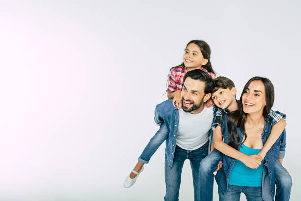 zdjęcie szczęśliwej pięknej rodziny odizolowanej na biało i patrzącej dalej - cztery osoby zdjęcia i obrazy z banku zdjęć