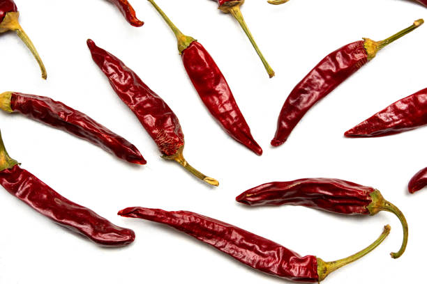 Dried red peppers on white background flat lay