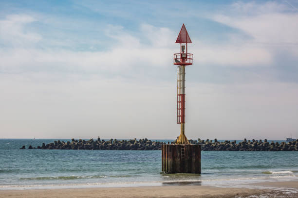 cartel de mar con muelle de piedra en la playa - arrival beacon blue nautical vessel fotografías e imágenes de stock