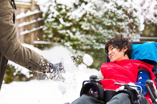 istock Disabled boy in wheelchair playing in winter snow 1132221946