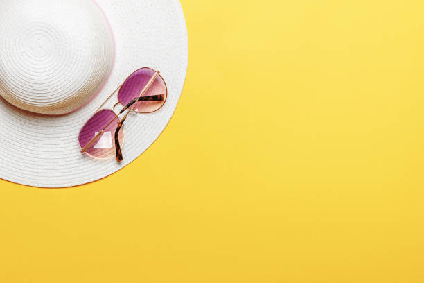 Beach Women's Hat Sun Glasses Top View Yellow Background Flat Single Beach Women's Hat Sun Glasses Top View Yellow Background Flat Single sun hat stock pictures, royalty-free photos & images