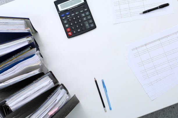 istock Binders with papers are waiting to be processed with bookkeeper. Internal Revenue Service inspector working place. View from above 1132222718