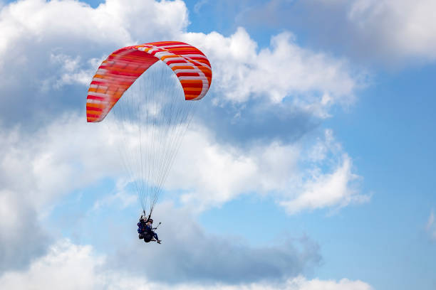 istock Paraglider flying against the blue sky with clouds 1132222930