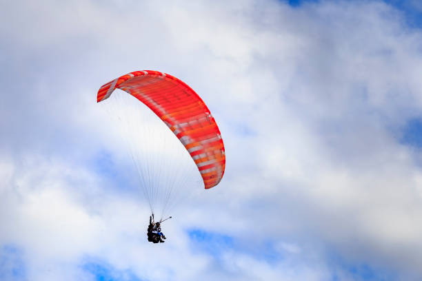 istock Paraglider flying against the blue sky with clouds 1132222996