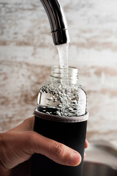 istock man filling a reusable water bottle from a tap 1132230179