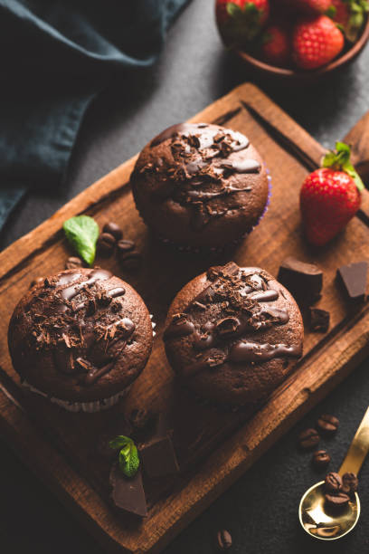 istock Dark chocolate muffins on wooden board 1132230869