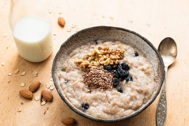 owies śniadaniowy w misce na drewnianym stole - oatmeal raisin porridge nut zdjęcia i obrazy z banku zdjęć