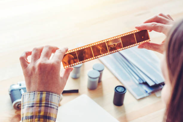 Photographer examining film negative in photo studio