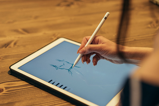 Female designer using graphic tablet and stylus pen