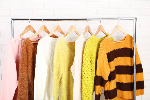 istock Fashion sweaters hanging on brick wall background 1132236333