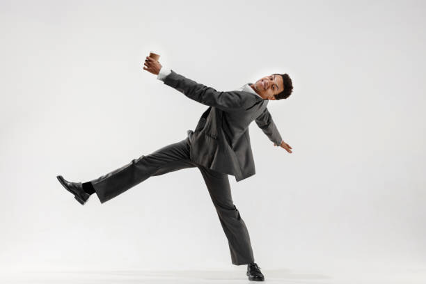 istock Happy businessman dancing isolated on gray studio background 1132239844