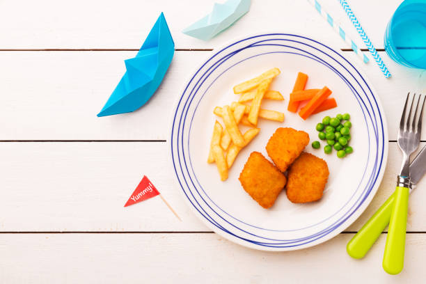istock Kid's meal (dinner) - fish, chips, carrot and green peas 1132243974