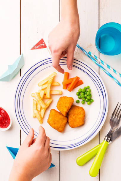 istock Kid's meal (dinner) - fish, chips, carrot and green peas 1132243976