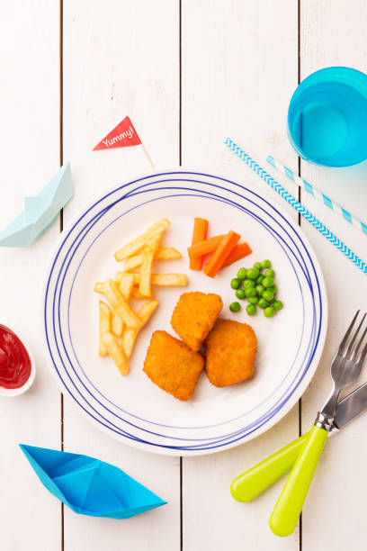 istock Kid's meal (dinner) - fish, chips, carrot and green peas 1132243983