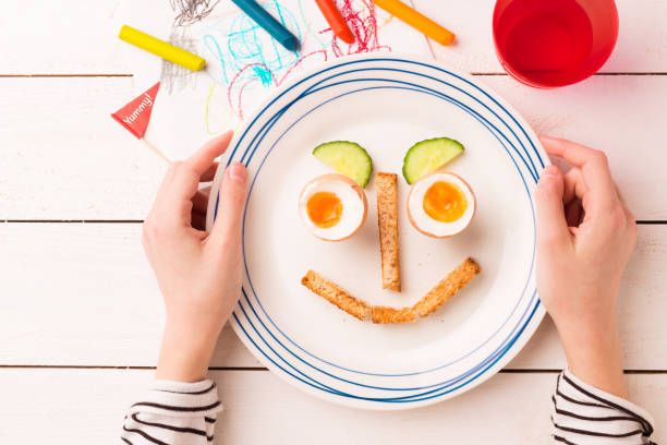 istock Funny breakfast in child's hands - eggs and toasts 1132244021
