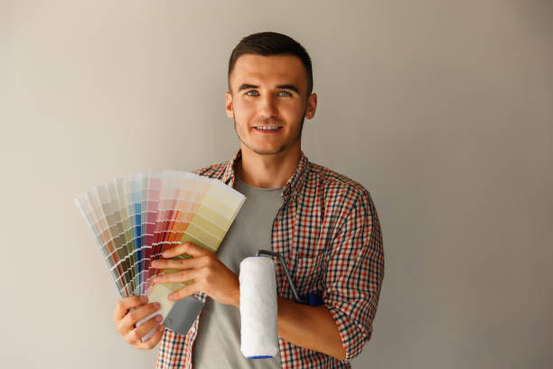 istock Man holding color palette and paint roller and looking to camera 1132244287