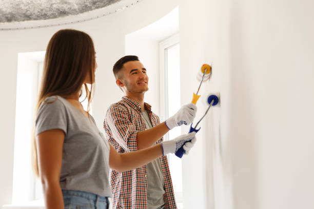 istock Happy Couple Painting a Wall with a Paint Roller 1132244298