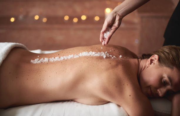 istock Female therapist spill mineral salt on lady back 1132244418