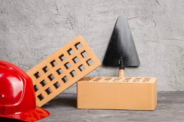 New bricks, trowel and red construction helmet