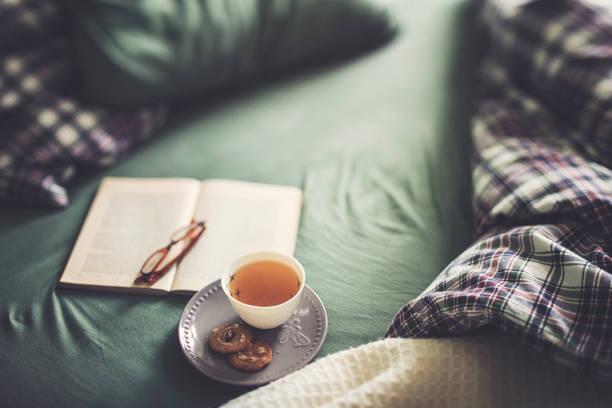 Crumpled bedding with tea and book for a relaxing day