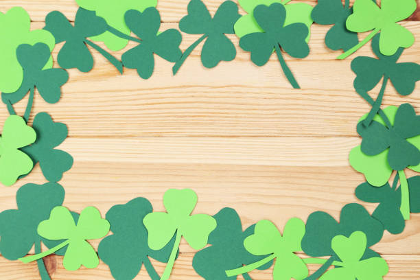 istock Paper clover leafs on brown wooden table 1132248448