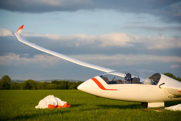 After a flight, a glider is parked on the ground and lashed for the night