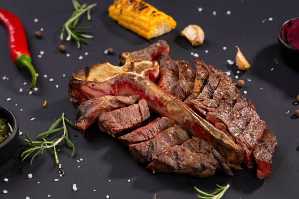istock Medium rare grilled Steak Ribeye Black Angus with corn and rosemary on serving on black background 1132251037