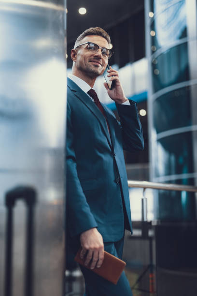 istock Attractive man looking aside and speaking on cellular phone 1132254432