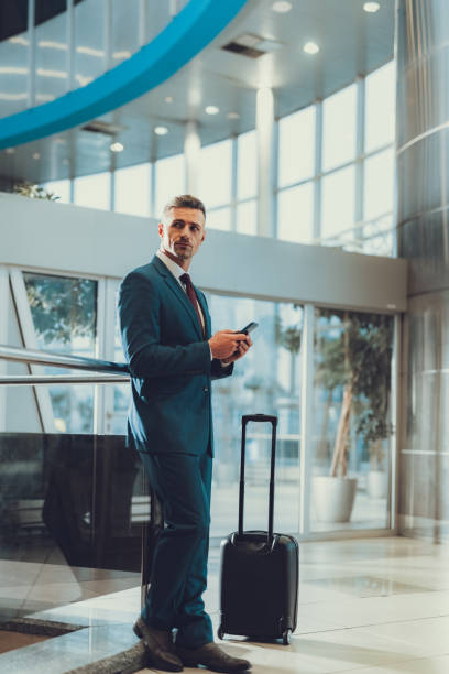 istock Man with suitcase using telephone and waiting departure on trip 1132254483