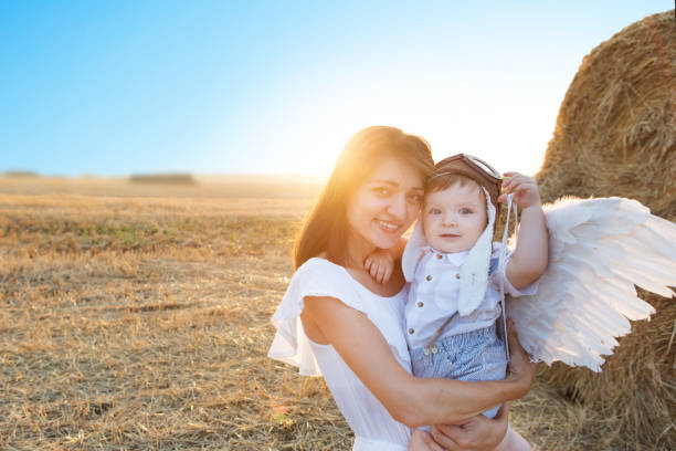 mamá y joven hijo jugando en el campo. - heaven women sunrise inspiration fotografías e imágenes de stock