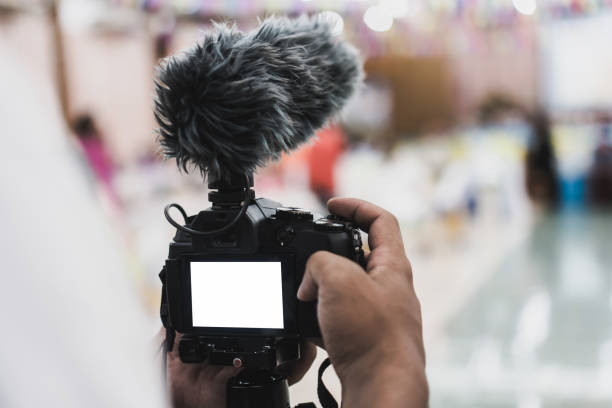 istock Cameraman Video or professional digital mirrorless on tripod for camera recording with microphone taking photograp in wedding convention hall in live streaming event, seminar production equipment. 1132261526