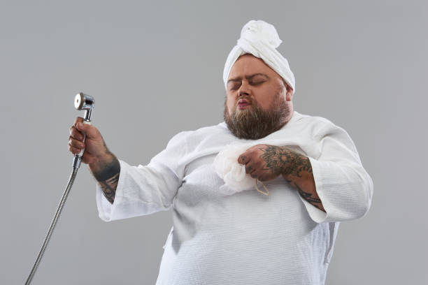 istock Funny overweight man closing his eyes while dancing with bath supplies 1132261563