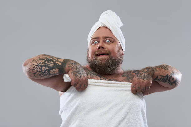 istock Expressive positive overweight man wearing soft white towel after shower 1132261579
