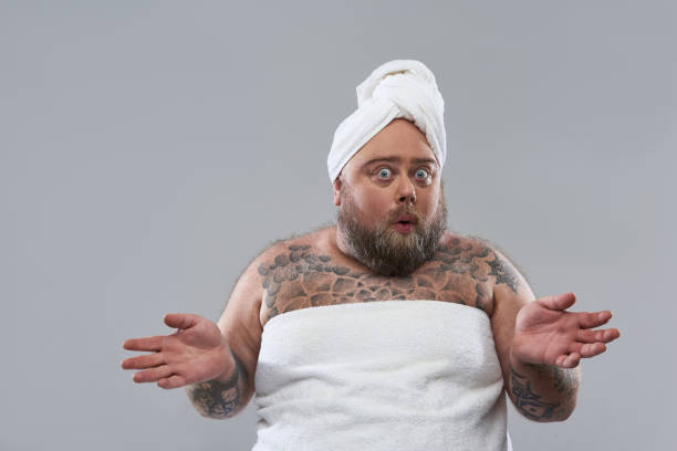 istock Surprised man in towel putting hands aside and looking funny 1132261584