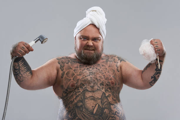 istock Funny overweight man showing his muscles while being ready for the shower 1132261586