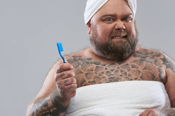 istock Close up of man holding toothbrush while biting his lips 1132261604