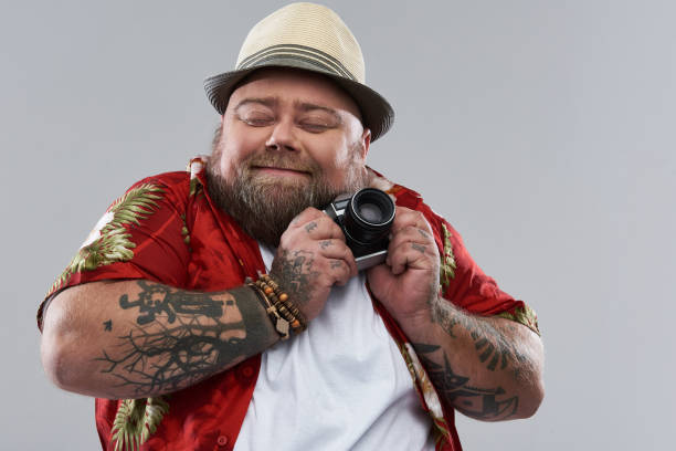 istock Adorable bearded man smiling and hugging his retro camera 1132261608