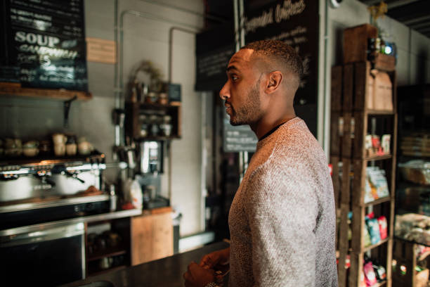 Mid-adult man is waiting to pay for his lunch in a cafe.